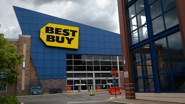 An exterior photo of a store with the Best Buy logo on a cloudy day.