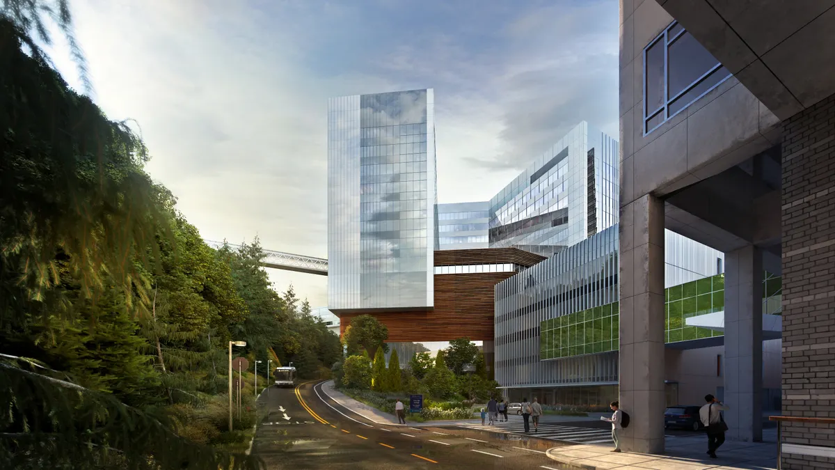 A rendering of a large, modern hospital covered with glass, opposite a large hill covered in trees.