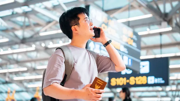 A person talks on the phone while in an airport.