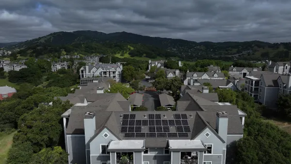Aerial view showing solar panels on the roof of an apartment building.