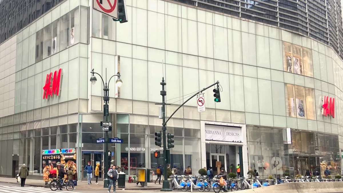 People, bikes and a food stand on a city corner.