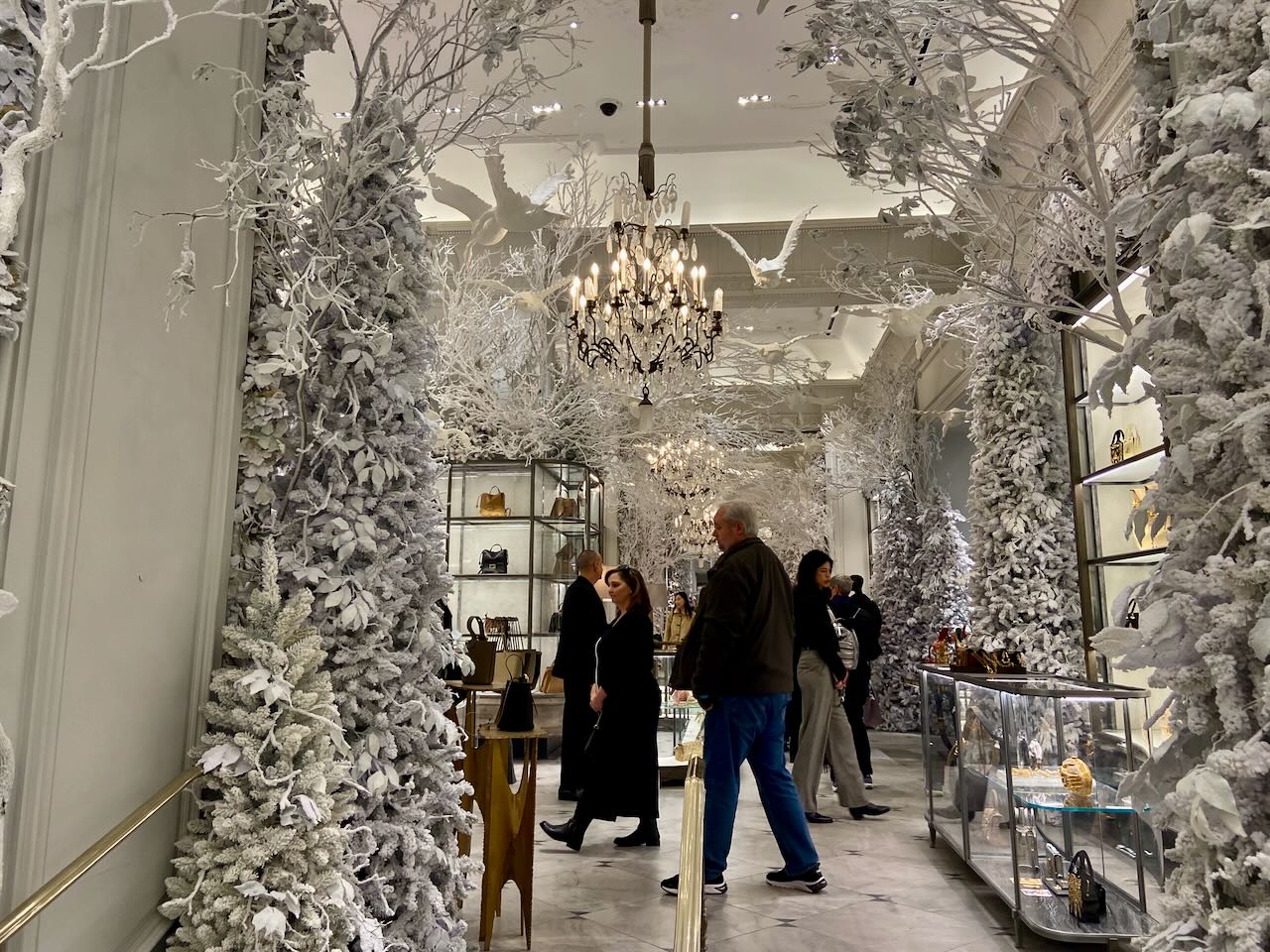 People walking around a store that is decorated for the winter holidays.