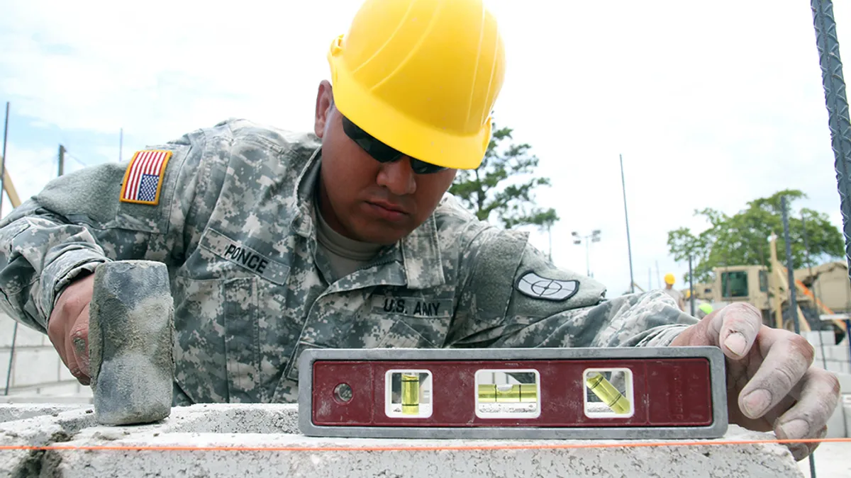 Alfredo Ponce, a carpenter with the 808th Engineer Company, levels a cinder block on the foundation of a new medical clinic April 15, 2017, during a construction project at Double Head Cabbage, Belize