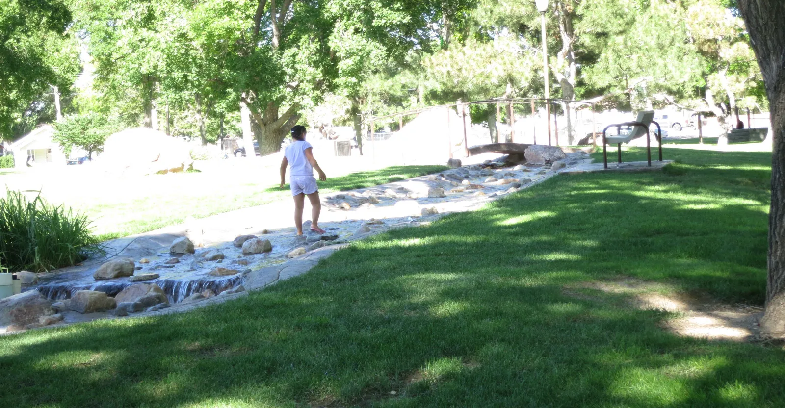 A child plays in a fountain in a city park in Delta, Utah