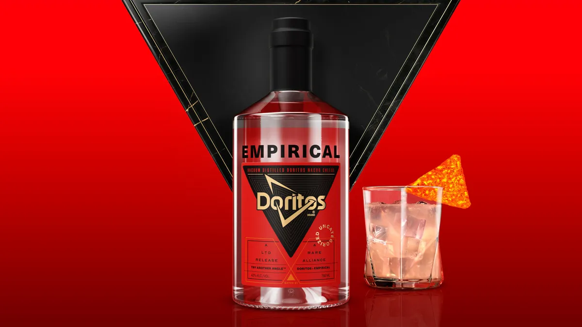 The Doritos x Empirical nacho cheese spirit bottle paired next to a glass with a Dorito chip garnish