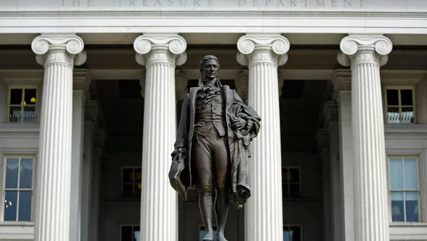 A statue of the first United States Secretary of the Treasury Alexander Hamilton stands in front of the U.S. Treasury.