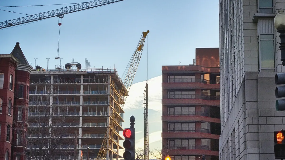 Construction cranes and street light at sunrise