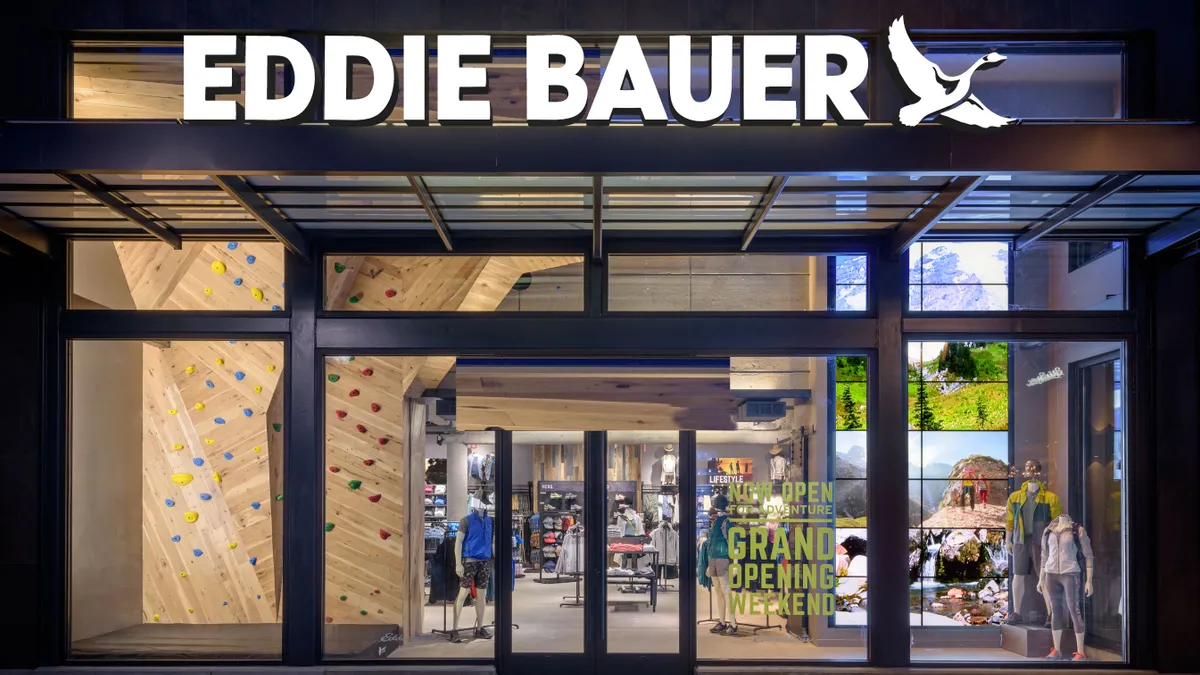 An Eddie Bauer storefront, with a climbing wall visible behind the front glass doors and windows.