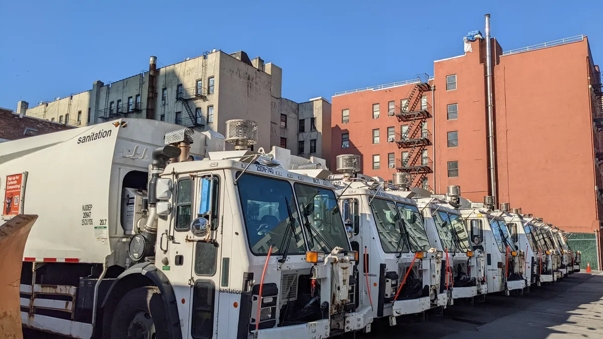 Row of white New York City Sanitation trucks