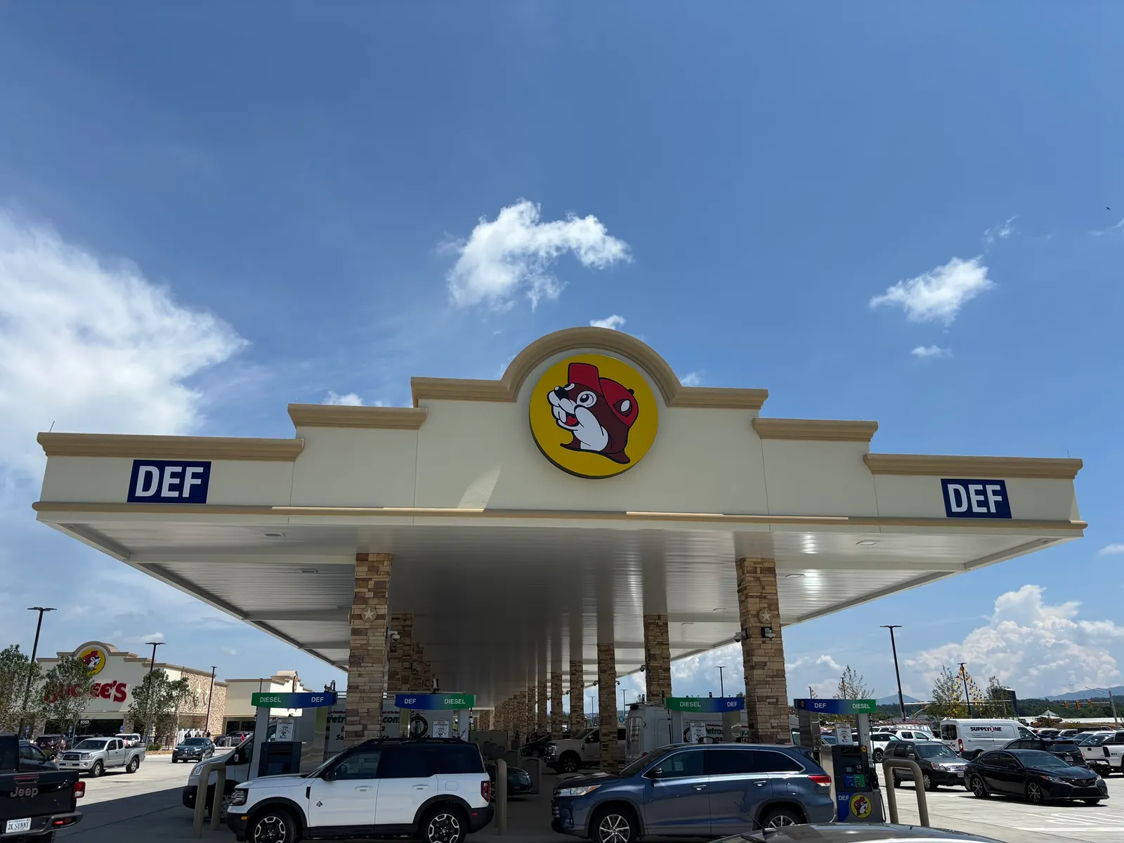 A photo of the fuel canopy at a gas station. A logo on the canopy shows a beaver wearing red clothing inside a yellow circle.