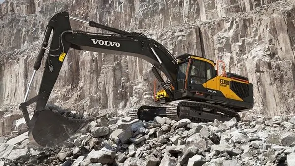 A large Volvo crawler excavator on some rubble in a quarry.