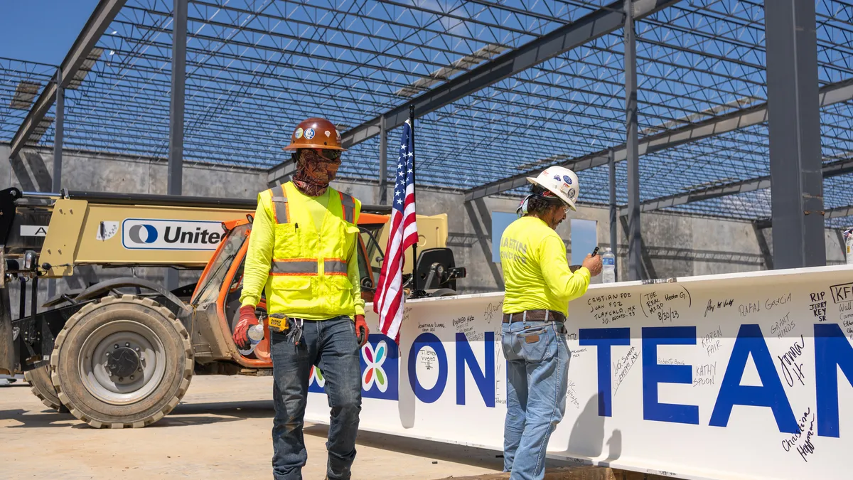 Workers place the final structural beam at a new $425 million state-of-the-art manufacturing facility in Jackson, Tennessee.