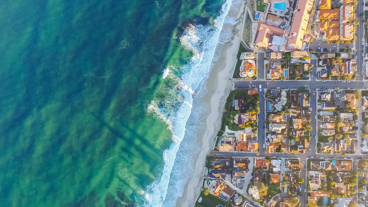 Aerial view of coastline where ocean meets development