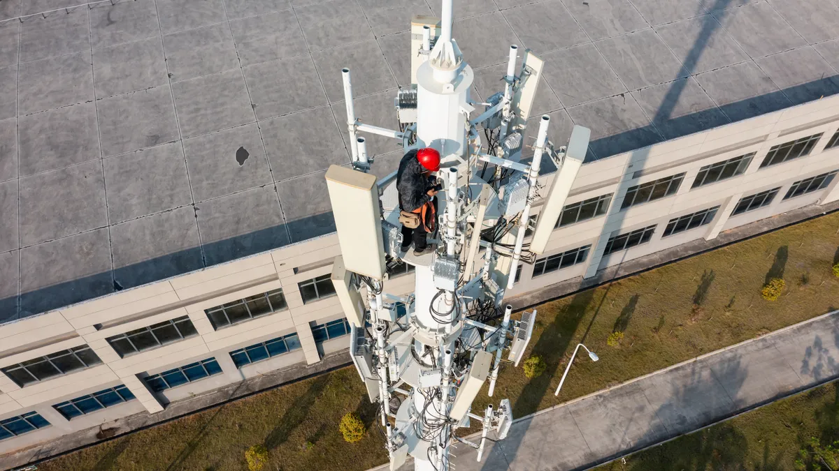 Engineer repairs 5G cell tower.