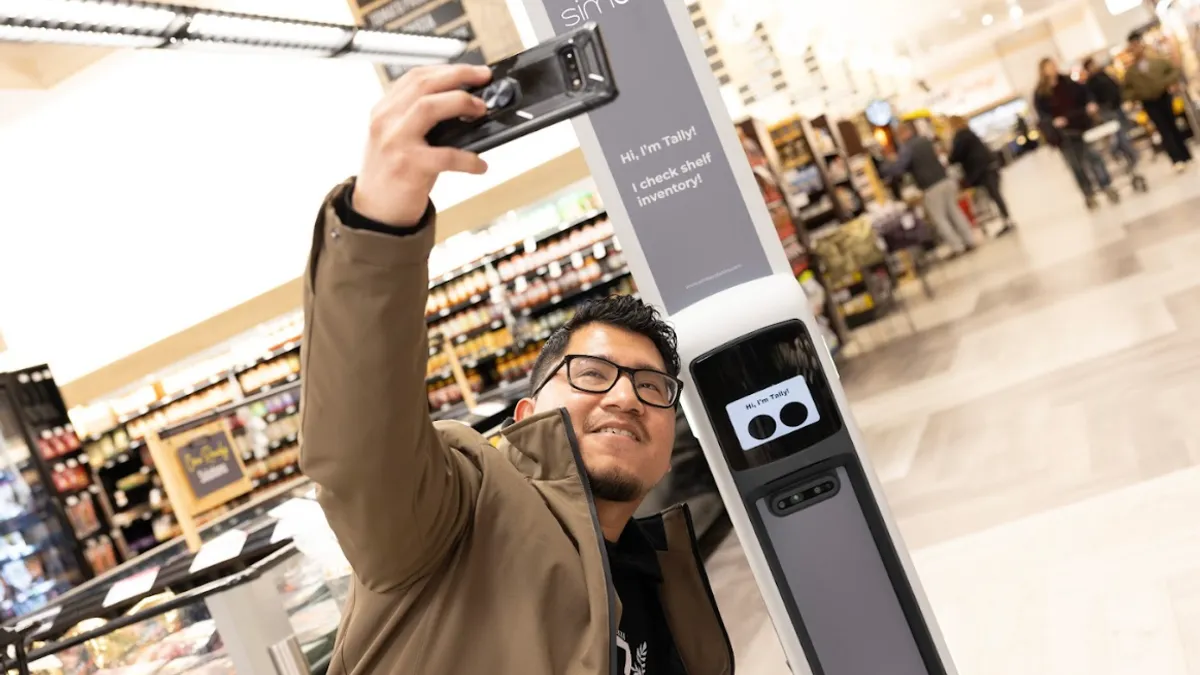 A person taking a selfie with an in-store robot.