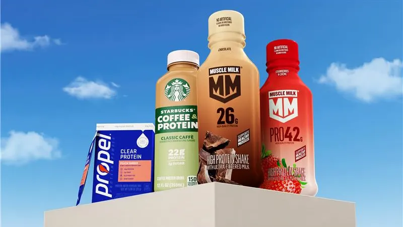Four beverage products are placed next to each other in front of a sky background.