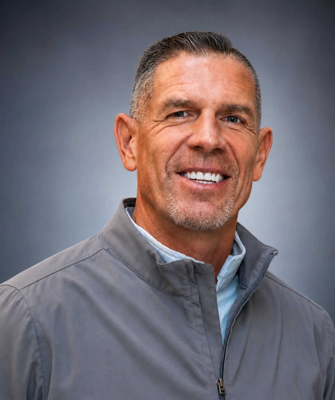 A head and shoulders shot of a person against a gray background.