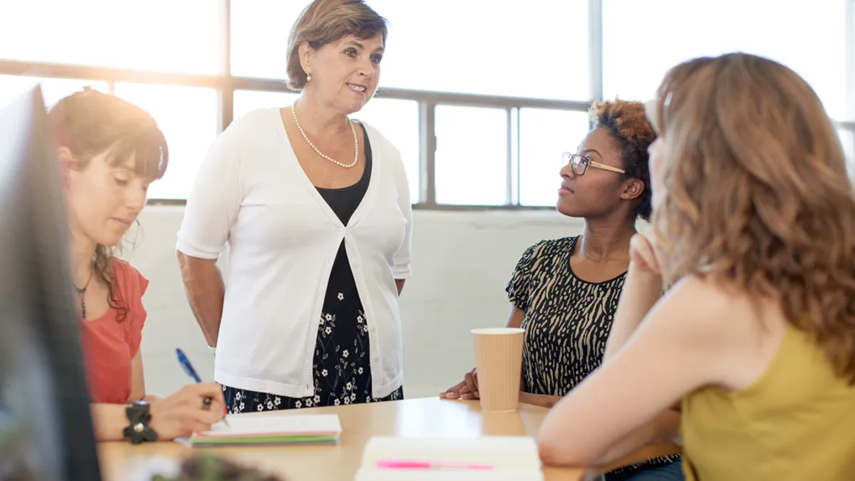 Teacher leader talking to other teaching professionals.