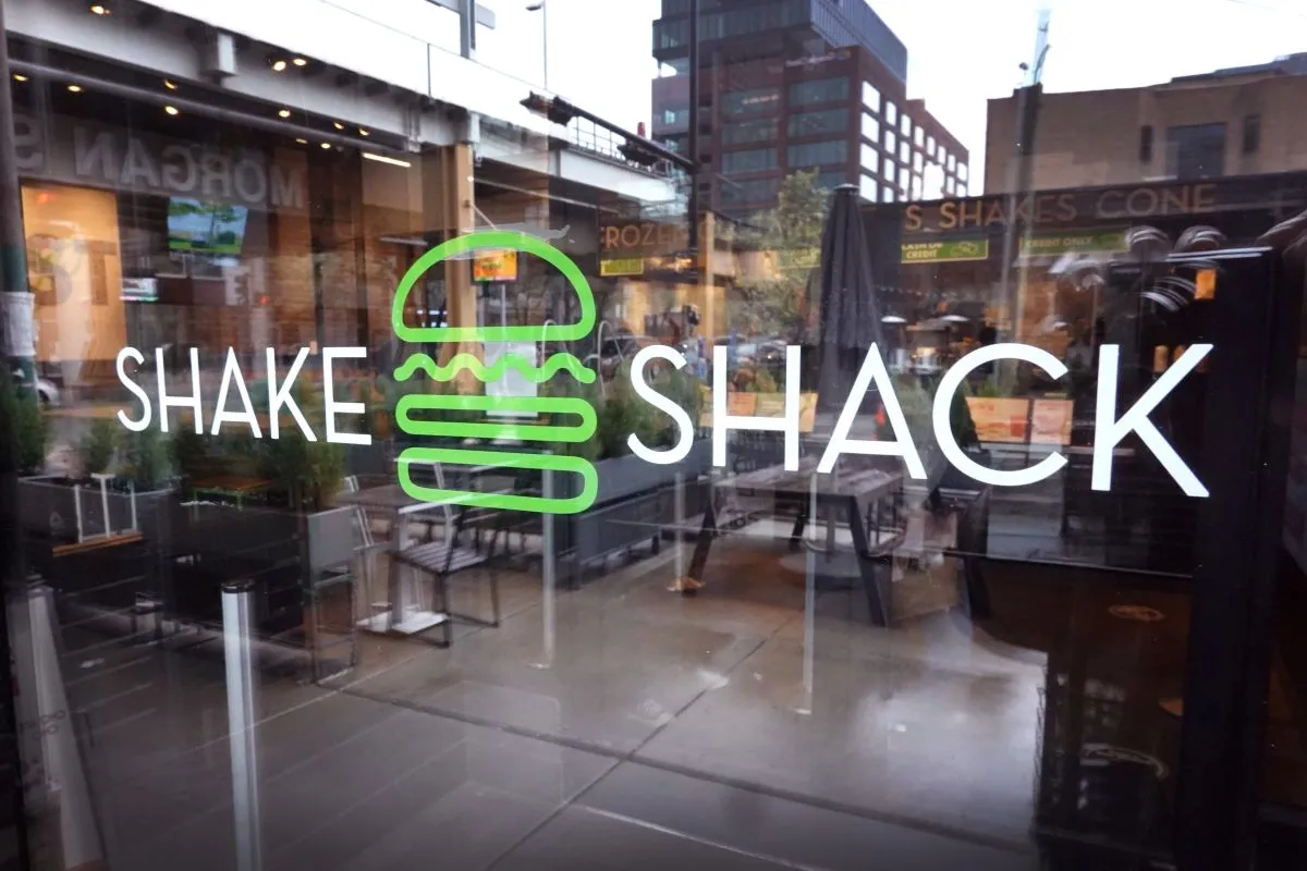 An image of the Shake Shack logo on a window.