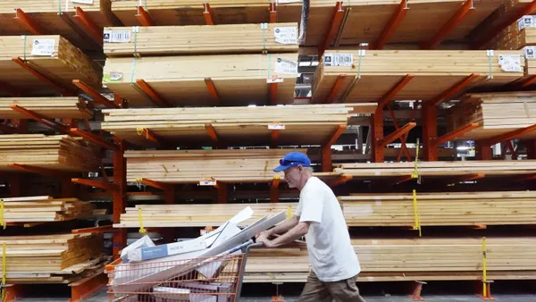 A customer walks through the lumber section of a Home Depot store