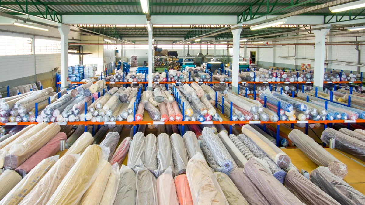 Photo of colourful rolls of fabrics, at a fabric warehouse.