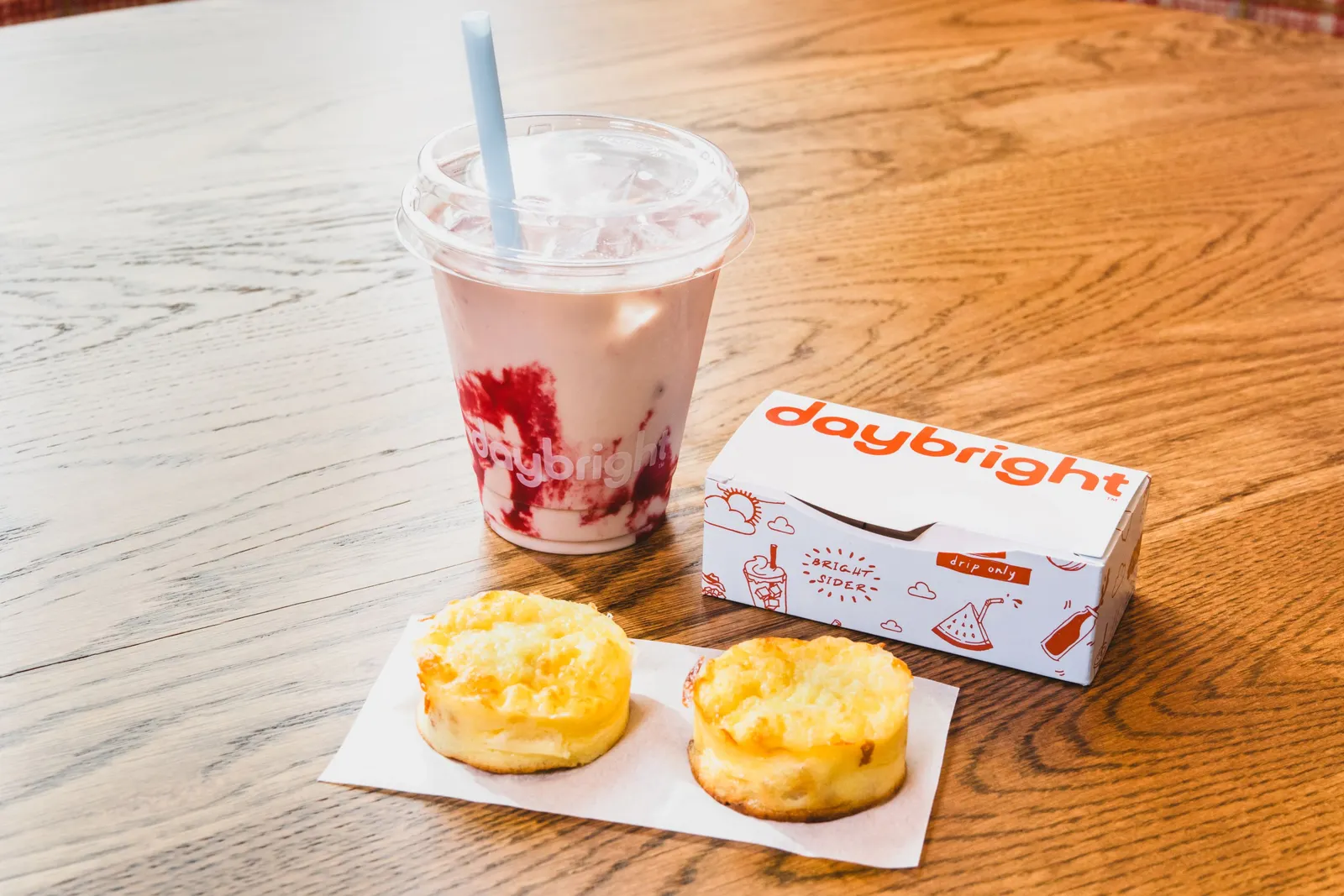 An image of two egg bites on a white napkin in front of a small smoothie.