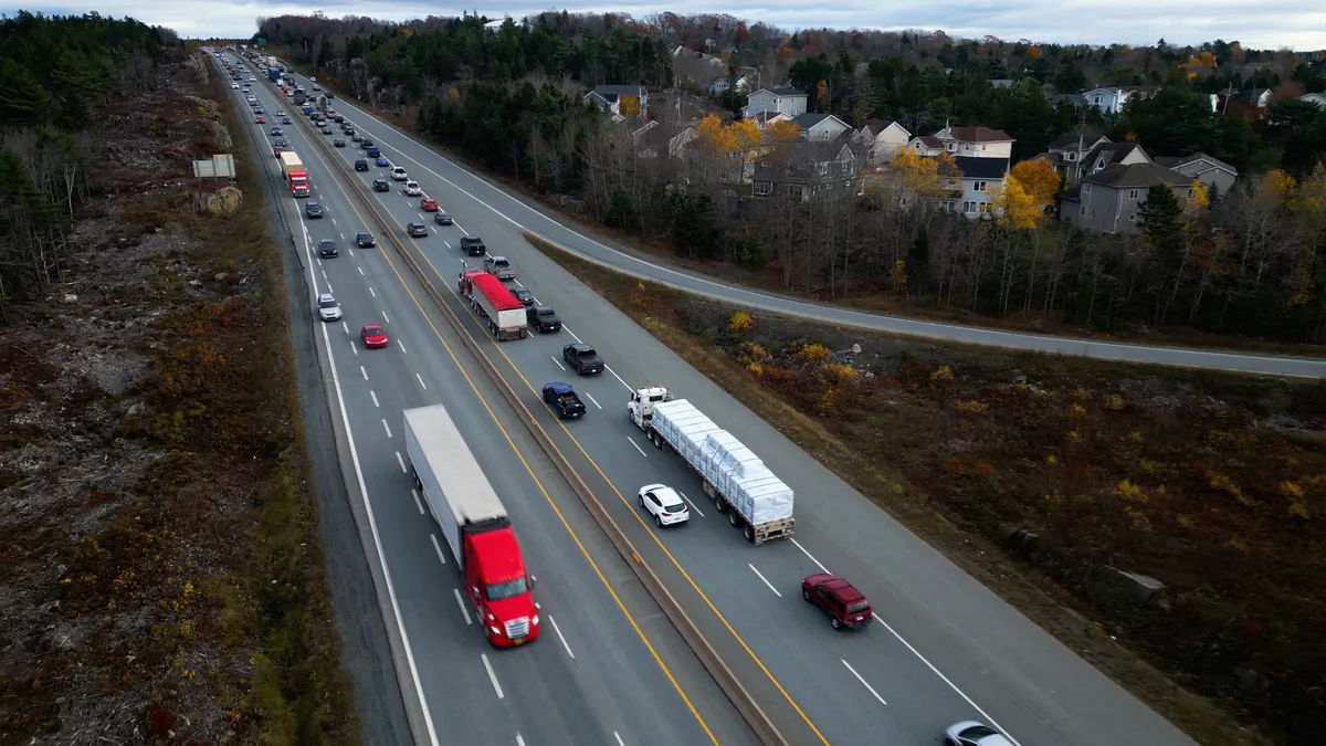 Passenger cars and heavy-duty trucks traverse a highway.