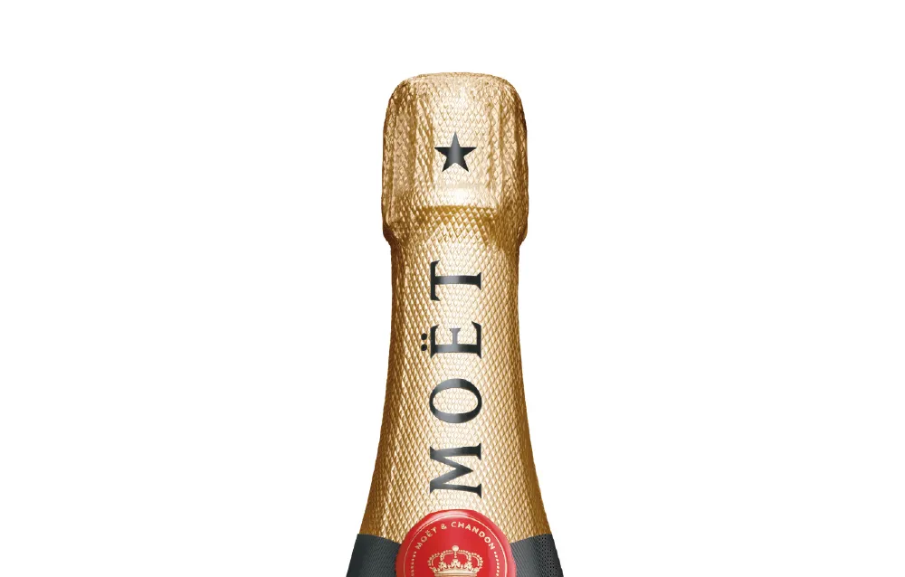 A close-up shot of the gold-colored foil cover on a bottle of Moet sparkling wine.