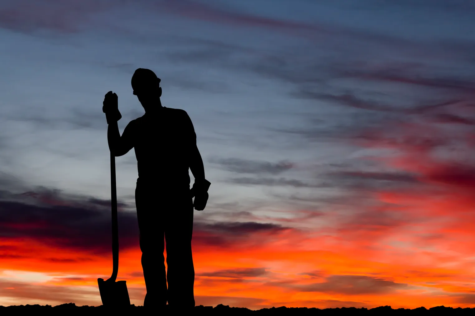 A lone construction worker pauses on a jobsite.