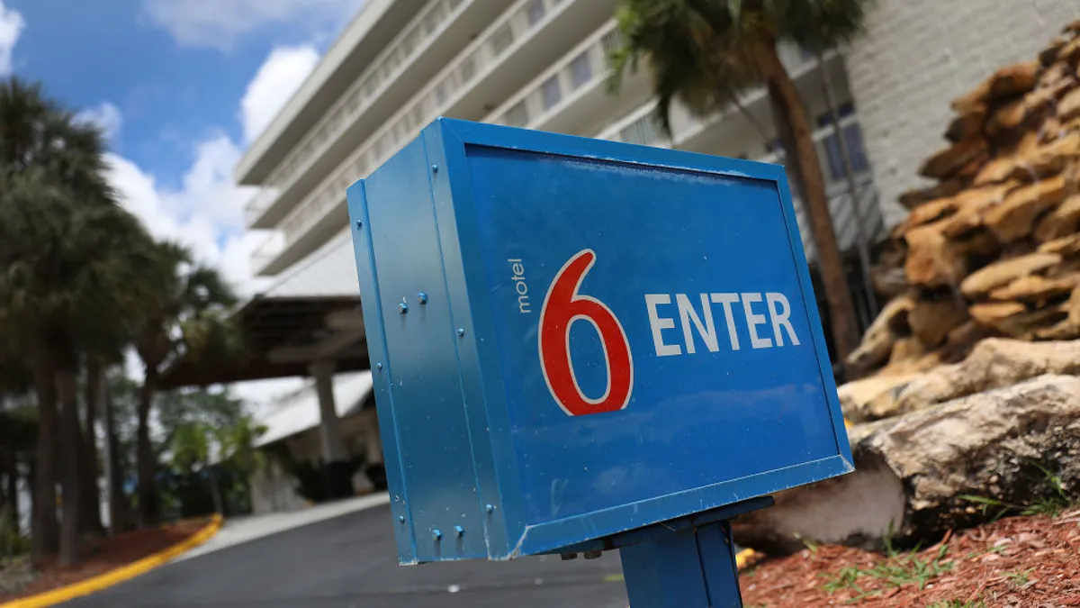 A Motel 6 sign is seen outside of a hotel building.