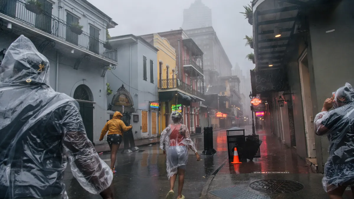 A group of people walk through the French District during Hurricane Ida on August 29, 2021 in New Orleans, Louisiana.