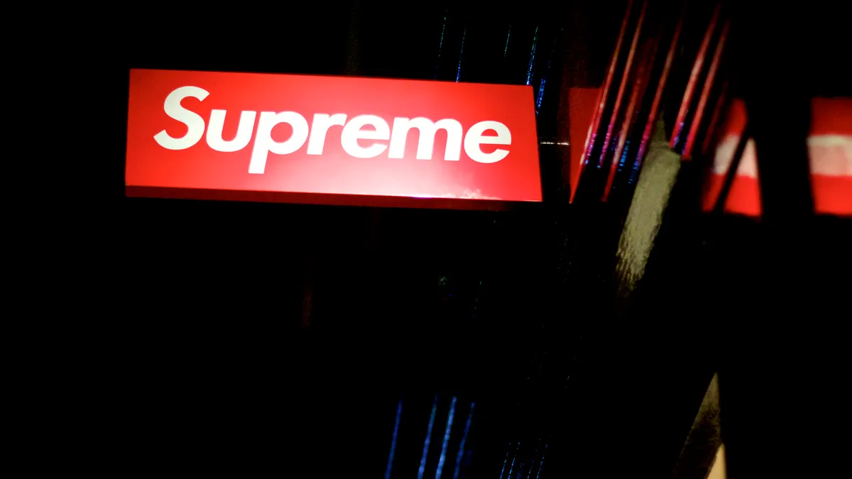 The Supreme logo on a sign is pictured outside a storefront.