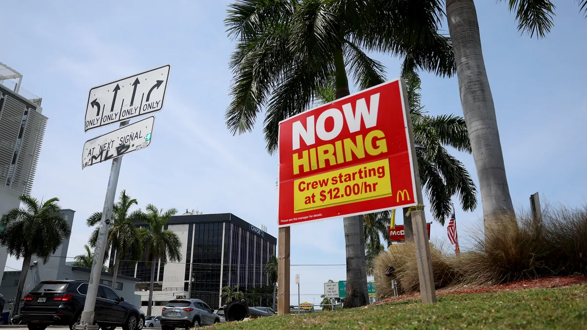 A sign advertises job openings at McDonald's starting at $12 per hour.