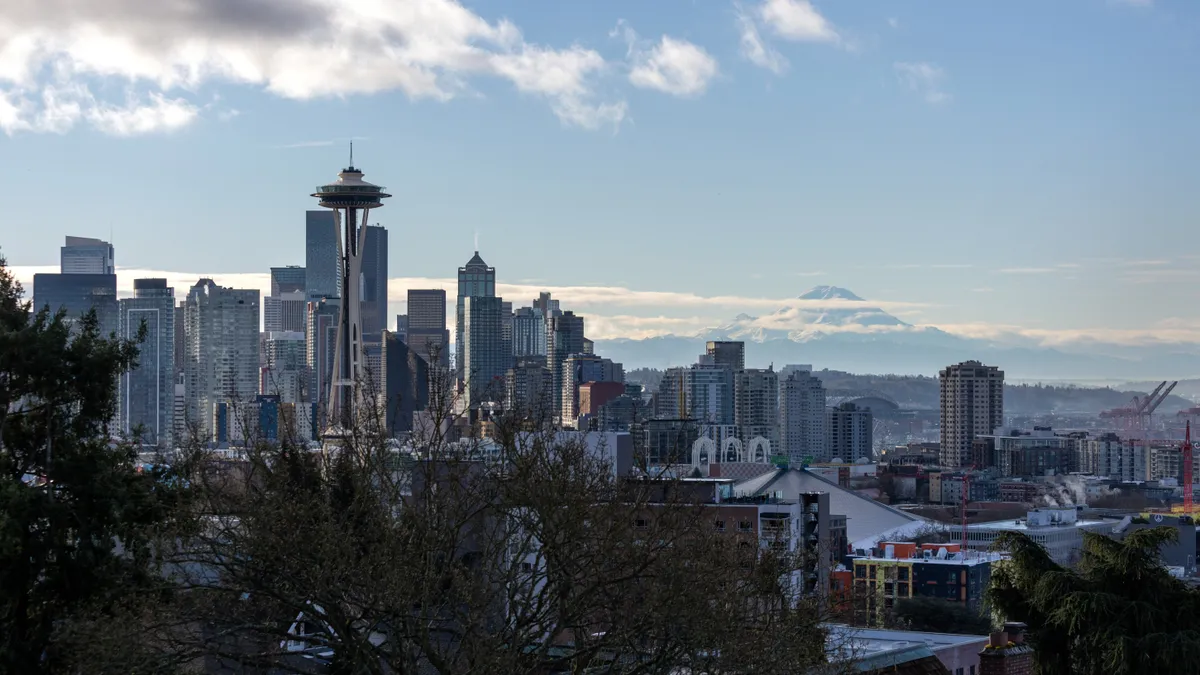 The Space Needle stands over the Seattle skyline as Mt. Rainier is seen in the background.