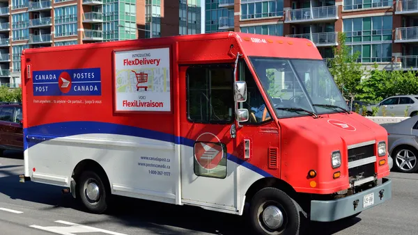 A Canada Post delivery truck on the road.