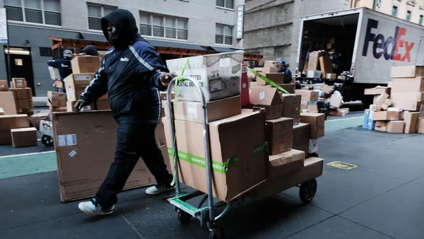 A FedEx deliver worker moves a cart with packages on Dec. 6, 2021 in New York City.