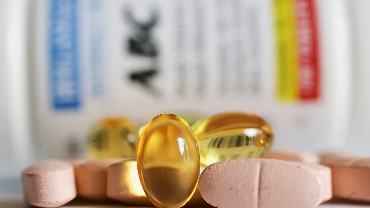 vitamins in front of a blurred out medication bottle