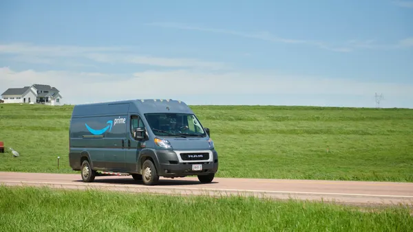 A delivery van drives down a rural road.