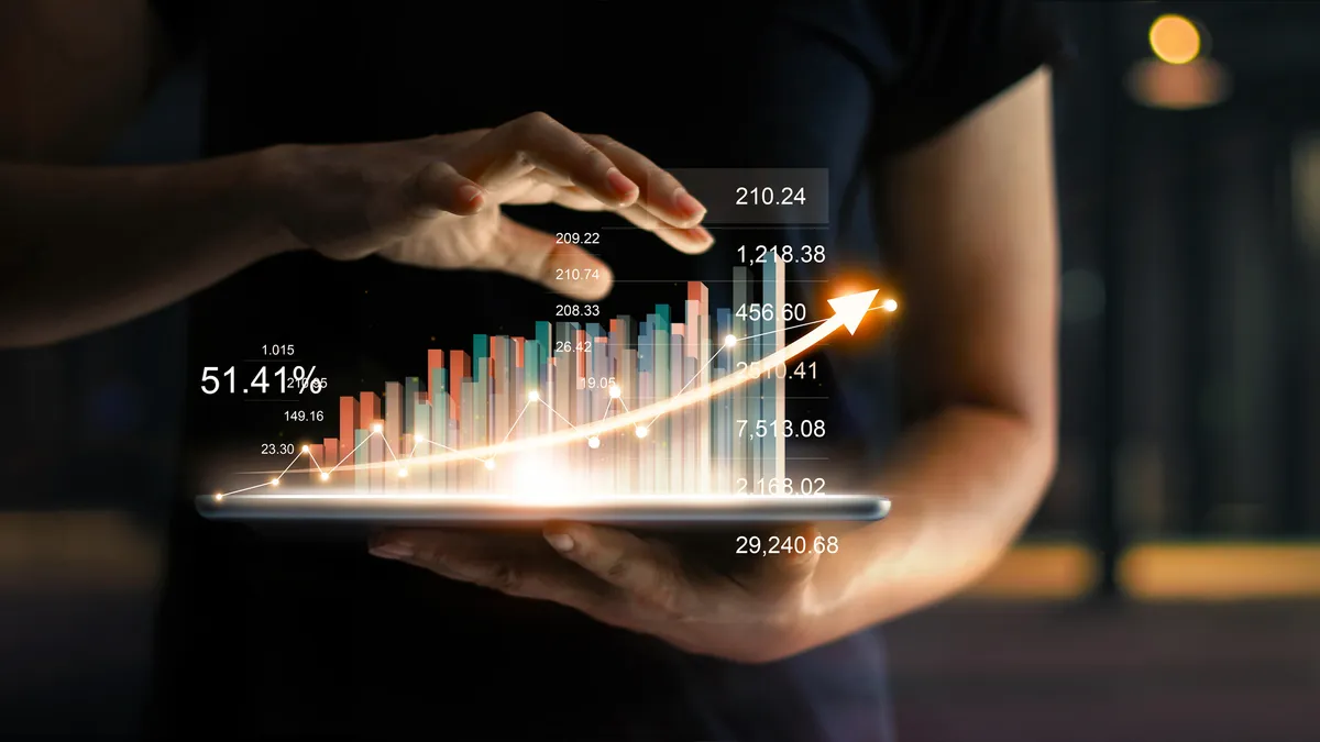 A businessperson holding a table showing a virtual hologram of statistics