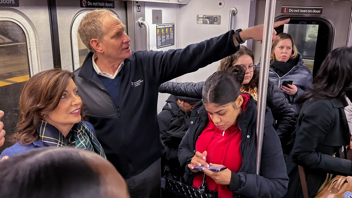 The New York City transit chief stands alongside Gov. Kathy Hochul on a crowded subway car.