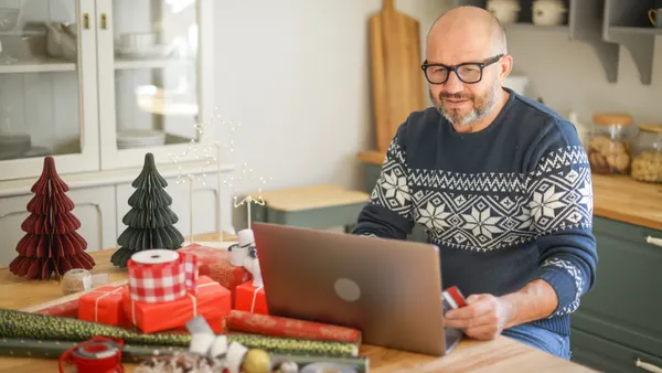 A customer browses a computer in front of a Christmas tree.