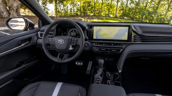 The dashboard and instrument cluster in a 2025 Toyota Camry Hybrid SE trim with a black interior.