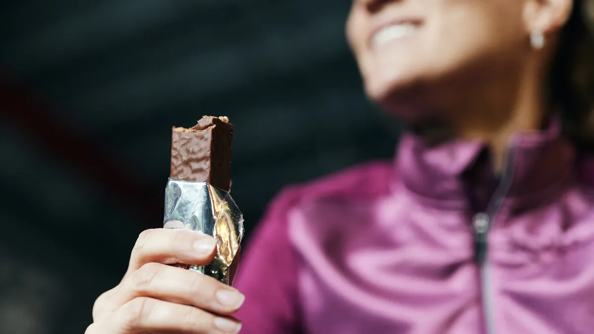 woman eats protein bar