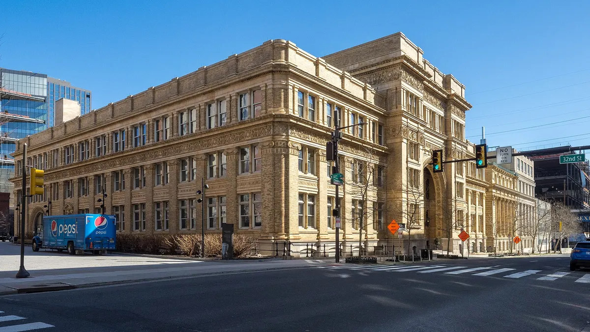 Large white academic building taking city block.