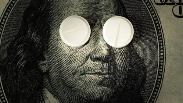 pills lie instead of eyes on a one hundred dollar bill in close-up.