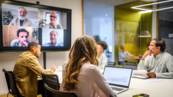 Business people video conferencing in board room