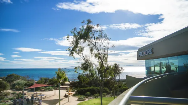 The exterior of a level office as it overlooks the water. The name on the top of the office is "Procore."