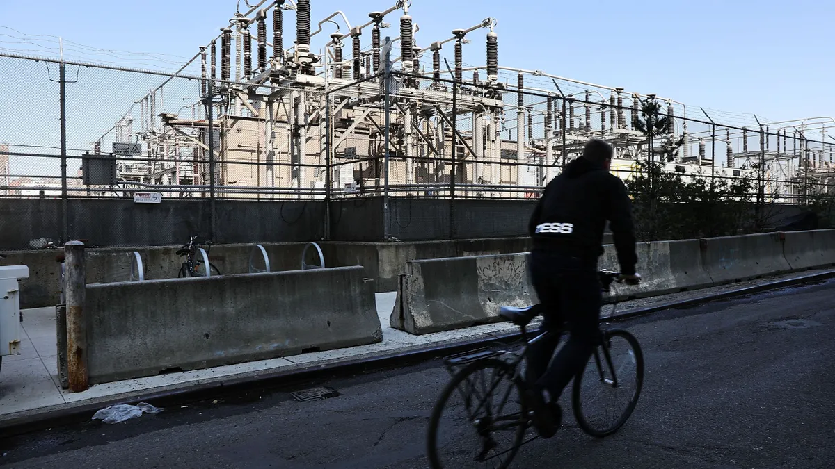 A person riding a bike past a power plant