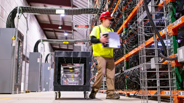 A man carries a box in a warehouse.