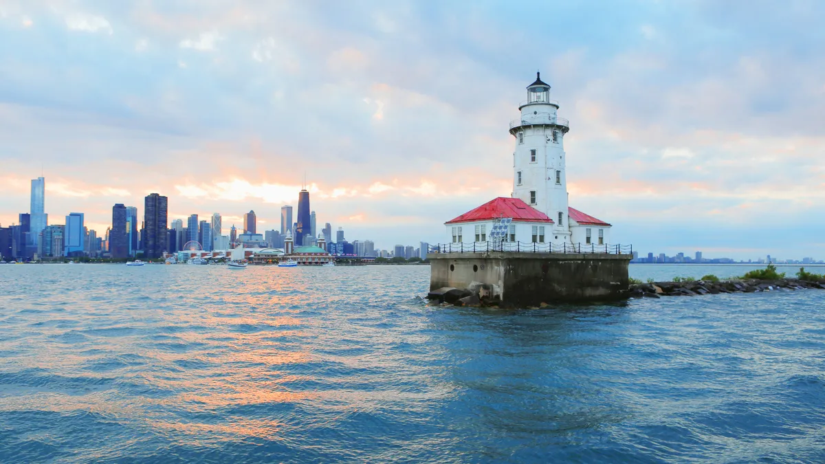 Lighthouse in a lake, city skyline in background